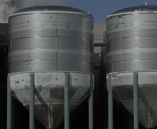 Background with dark overlay of close-up of field erected brewery tanks.