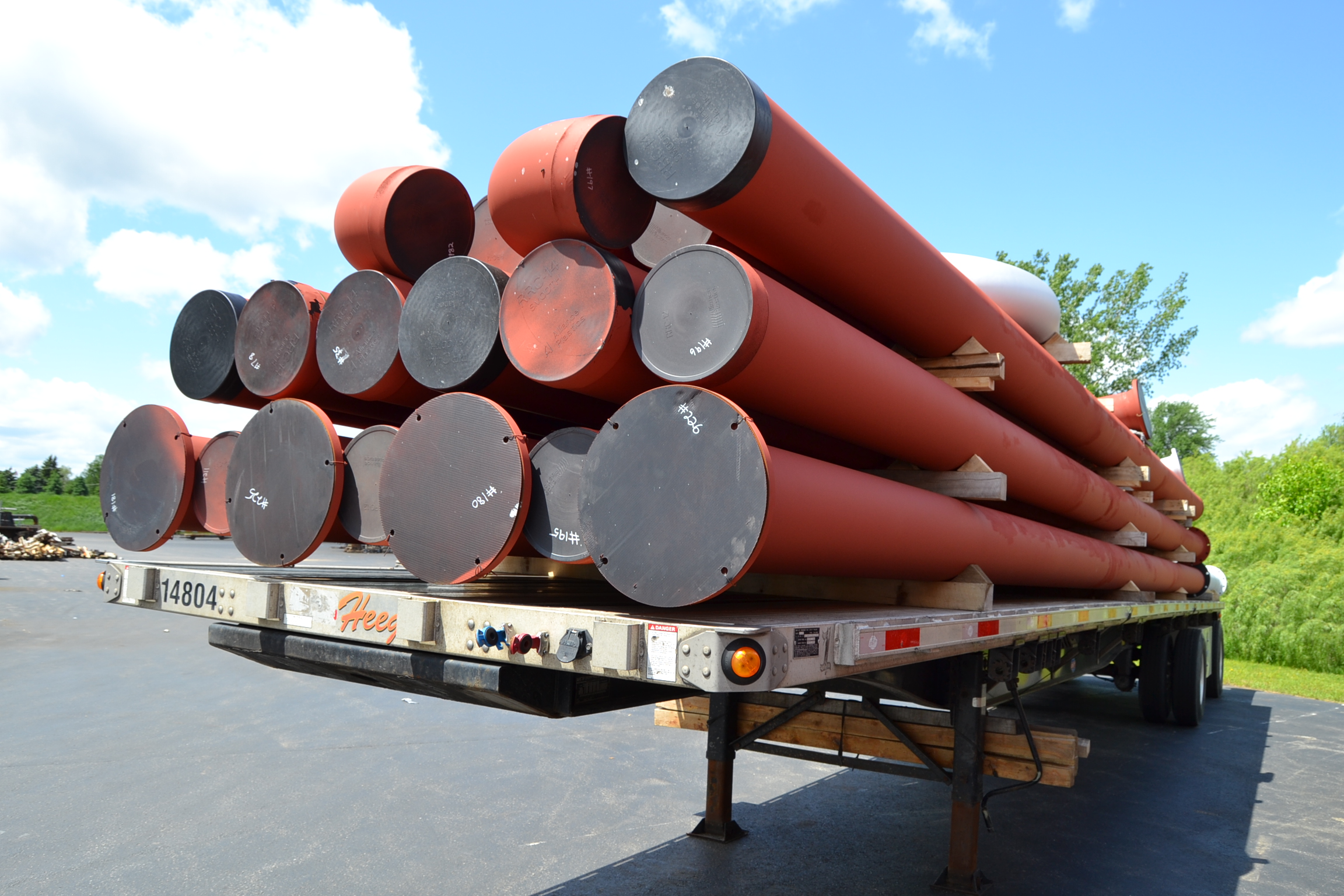 Piping loaded on a flatbed truck outside a pipe fabrication shop.