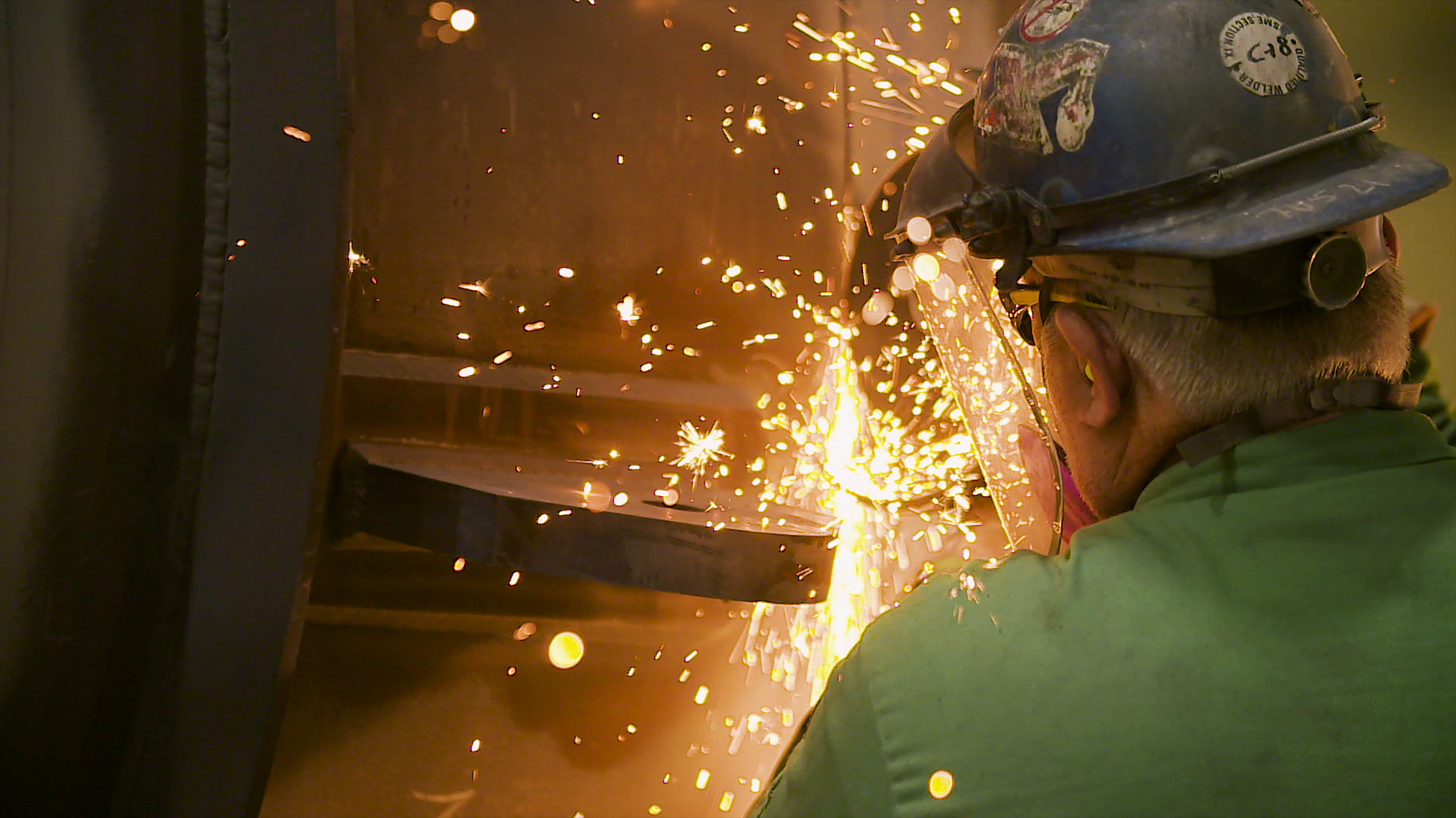 Man grinding steel for maintenance during a shutdown, turnaround, & outage.